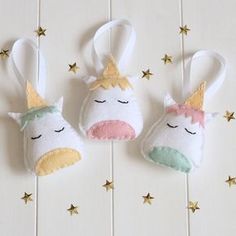 two stuffed unicorns are hanging on the wall with gold stars around them and one is wearing a crown