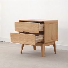 two wooden drawers sitting on top of each other in front of a white wall and floor