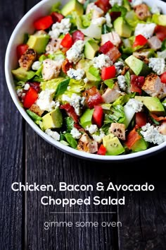 chicken, bacon and avocado chopped salad in a white bowl on a wooden table