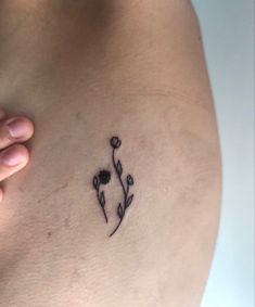 a woman's stomach with a small flower tattoo on it