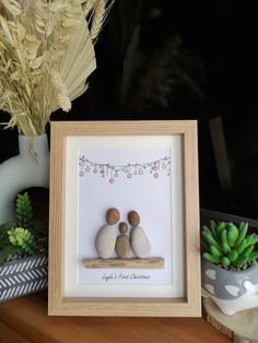 two pebbles sitting on top of a wooden table next to a potted plant