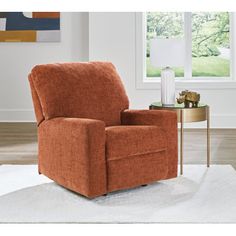 an orange recliner chair sitting on top of a white rug