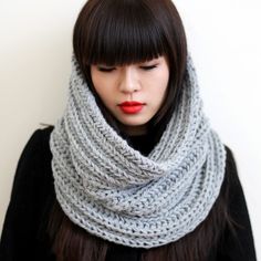 a woman wearing a gray knitted scarf