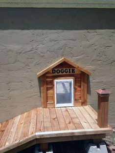 a dog house built into the side of a building that has a door and window