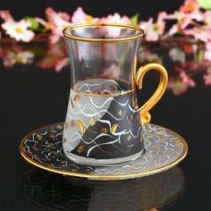 a glass cup and saucer on a black table