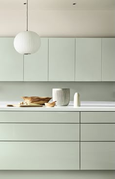 a kitchen with white cabinets and counter tops