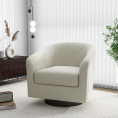 a white chair sitting on top of a rug in a living room next to a window