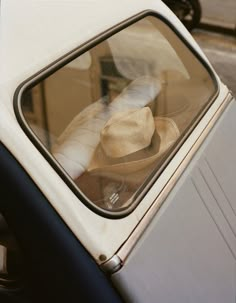 an old car with a hat on the window