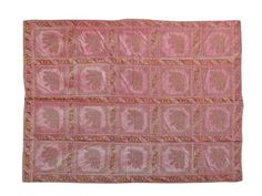 an old pink and gold cloth with letters on it