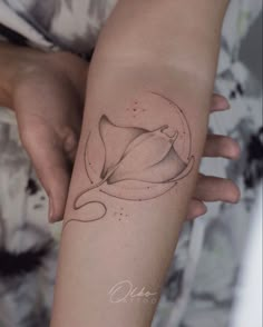 a woman's arm with a flower tattoo on the left side of her arm