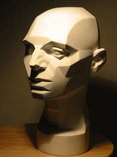 a sculpture of a man's head sitting on top of a wooden table