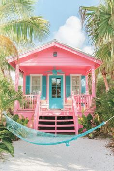 a pink and blue house with hammock in front