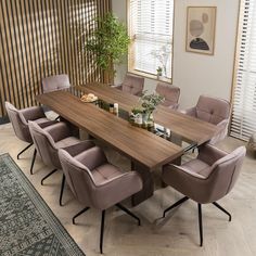 a dining room table with six chairs and a potted plant on the end shelf