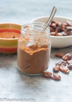 a jar filled with nuts next to a bowl of raisins