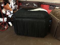 a black ottoman sitting next to a brown footstool on top of a floor