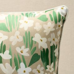 a green and white pillow with flowers on it