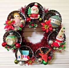 a christmas wreath is hanging on the wall with ornaments and decorations in front of it