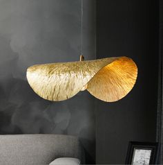 a living room with a couch and lamp hanging from the ceiling