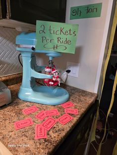 a kitchen counter with pink stickers on it and a blue mixer in the middle