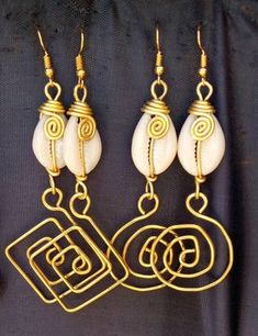 The earrings are  made with a lot of love and care from cowries and brass.   The wire is coiled to give a stunning look.  The are  beautifully designed for you, sister, mother, relative or a friend. The are light in weight and comfortable to wear. **This listing is for two pairs of earrings.** Buy multiple items pay shipping for one the rest ships free. Custom orders are welcome. For more earrings, follow the link. https://www.etsy.com/listing/697317594/african-earrings-gift-for-her-earrings?ref=related-1 **Happy shopping** Dhl shipping express Thank you. Unique Gold Earrings For Beach, Cowrie Shell Dangle Earrings As Gift, Handmade Cowrie Shell Earrings For Gift, Handmade Cowrie Shell Earrings As Gift, Cowrie Shell Dangle Jewelry Gift, Cowrie Shell Dangle Jewelry For Gifts, Unique Gold Shell Earrings, Gold Cowrie Shell Earrings As Gift, Gold Cowrie Shell Earrings For Gift