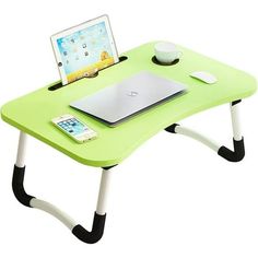 a laptop computer sitting on top of a green desk