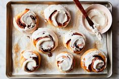 cinnamon rolls with icing on a baking sheet