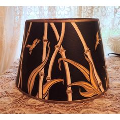 a black and gold lamp shade sitting on top of a table