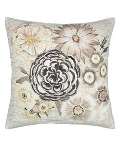 a decorative pillow with flowers on the front and back, in beige tones that are accented with black and white accents