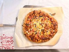 a pizza sitting on top of a piece of paper next to a knife and fork