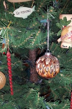 ornaments are hanging on the christmas tree in front of other ornaments, including an ornament that says go fishing