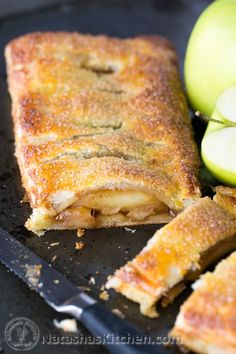 an apple pie is cut in half and ready to be eaten with a knife next to it