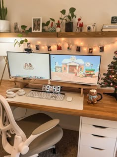 two computer monitors sitting on top of a desk next to a christmas tree and potted plant