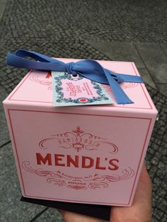 a pink box with a blue ribbon on it that says mendl's in english