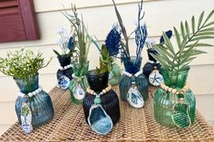 several vases with plants in them sitting on a table