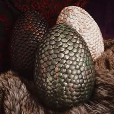 three eggs sitting on top of a fur covered surface