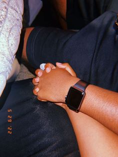 two people holding hands while sitting down