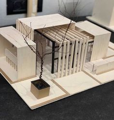 a model of a house with a tree in the center and two windows on each side