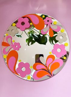 a round mirror with flowers painted on it