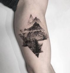 a man's arm with a mountain and forest tattoo on the left inner forearm