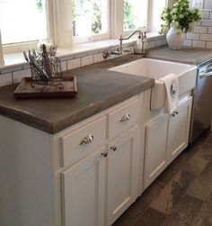 a kitchen with white cabinets and counter tops next to a dishwasher in the sink