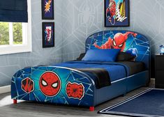 a child's bedroom with blue walls and spiderman bedding