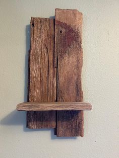 a wooden shelf mounted to the wall with two pieces of wood on top of it