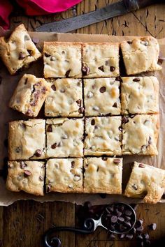 chocolate chip cookie bars cut into squares on top of parchment paper next to a pair of scissors