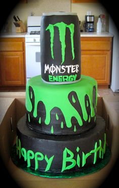 three tiered monster birthday cake with green icing and black frosting on top