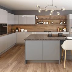 a modern kitchen with white cabinets and gray counter tops, wood flooring and hanging lights