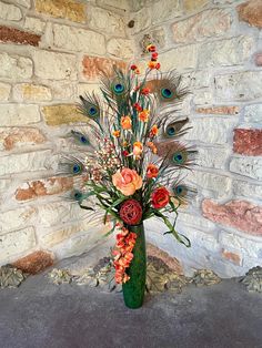 a vase filled with flowers and peacock feathers