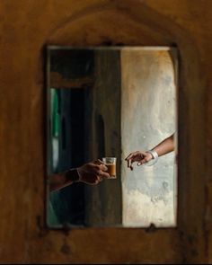 two people reaching out their hands to each other in front of a wooden wall with a mirror