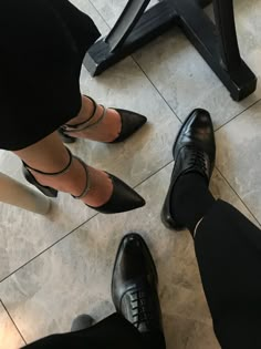 three people in black dress shoes standing next to each other