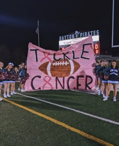 some cheerleaders are holding up a pink banner