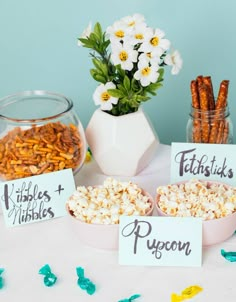 popcorn, marshmallows and other snacks are on the table for guests to eat